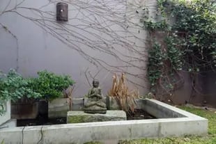 Una fuente de agua con un buda decora el exterior de la propiedad