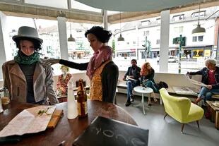 Los maniquíes, vestidos con estilo, se mezclan entre los clientes en este café de Essen, Alemania