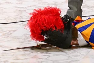 Un guardia suizo yace en el suelo tras desmayarse durante la audiencia general semanal del Papa el 17 de agosto de 2022 en la sala Pablo VI del Vaticano. 