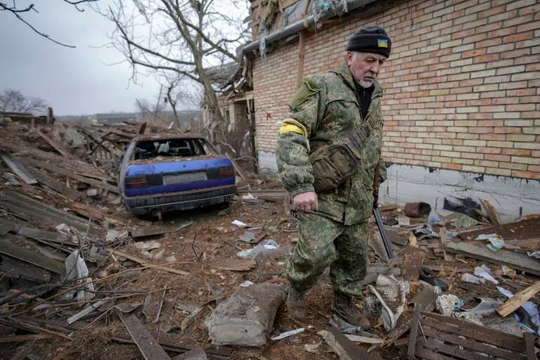 Andrey Goncharuk, de 68 años, miembro de defensa territorial, camina en el patio trasero de una casa dañada por un ataque aéreo ruso, según lugareños, en Gorenka, en las afueras de la capital, Kiev, Ucrania, el miércoles 2 de marzo de 2022