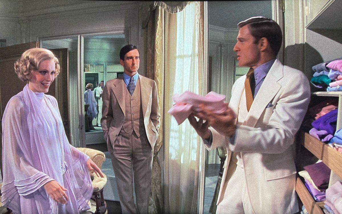 Robert Redford, en el papel de Jay Gatsby, con traje blanco de Ralph Lauren, muestra a Mia Farrow las camisas que le envía desde Londres un amigo, en el inicio de cada temporada. 