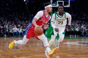 El base de los 76ers de Filadelfia, Seth Curry, deja atrás al base de los Celtics de Boston, Dennis Schroder, en la segunda mitad del partido del lunes 20 de diciembre de 2021, en Boston. (AP Foto/Charles Krupa)