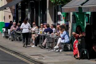 Personas disfrutan un día soleado en un restaurante de Soho, Londres, 