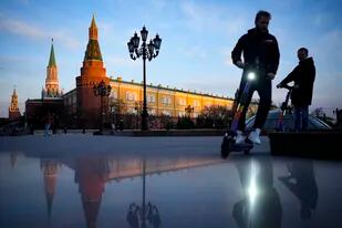 ARCHIVO - Dos jóvenes conducen motonetas eléctricas al atardecer en la Plaza Manezhnaya, cerca de la Plaza Roja y el Kremlin, el 20 de abril de 2022, en Moscú, Rusia. (AP Foto/Alexander Zemlianichenko, archivo)