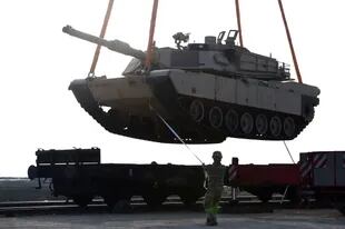 En esta foto de archivo tomada el 14 de febrero de 2017, un soldado estadounidense ayuda a maniobrar un tanque Abrams desde un vagón de ferrocarril mientras el personal del Ejército estadounidense descarga equipo militar