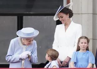 La Reina Isabel II habla con el Príncipe Louis, Catherine, Duquesa de Cambridge, y la Princesa Charlotte, en el balcón del Palacio de Buckingham, mientras observa el Trooping the Ceremonia de color en Horse Guards Parade, en el centro de Londres, el primer día de las celebraciones del Jubileo de Platino de la Reina Isabel II, el  de junio de 2022