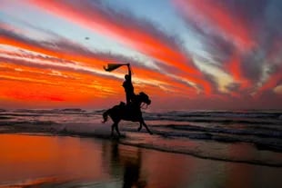 Un hombre palestino cabalga en la playa al atardecer unas horas antes del año nuevo en la franja de Gaza