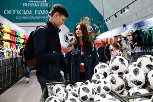 Visitantes recien llegados en la tienda oficial del FIFA Fan Fest en Moscú, con la pelota mundialista