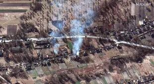 Esta imagen de satélite de Maxar tomada y publicada el 28 de febrero de 2022 muestra parte de un convoy militar y casas en llamas, al noroeste de Ivankiv, Ucrania. 