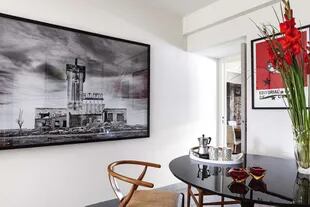 El matadero proyectado por el arquitecto Francisco Salamone en Carhué, en una foto firmada por Gonzalo Lauda, En el comedor diario, sillas ‘Wishbone’ con asiento de ratán y mesa ‘Tulip’ en su versión laca negra.