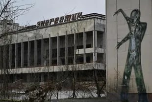 (FILES) A file photograph taken on December 8, 2020 shows a graffiti on a building wall on the central square of the ghost town of Pripyat, not far from Chernobyl nuclear power plant. - Ukraine's Chernobyl nuclear plant says 'completely halted' over Russian offensive. (Photo by GENYA SAVILOV / AFP)