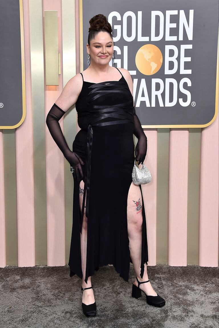 Megan Stalter se enfundó en un vestido negro acordonado, diseñado por Versace, que dejaba ver algunos de sus tatuajes