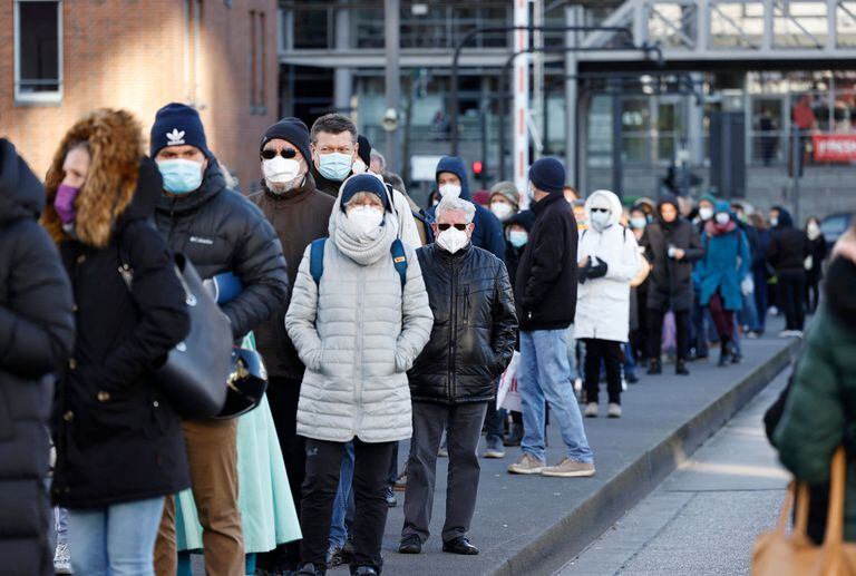 Las personas que llevan máscaras faciales hacen una cola de 700 metros para vacunarse en la Filarmónica del Elba 
en la ciudad de Hamburgo, en el norte de Alemania, el 22 de noviembre de 2021, ya que se ha abierto un centro de vacunación en medio de una oleada de infecciones durante la pandemia de coronavirus (Covid-19) en curso