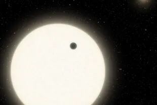 Esta ilustración muestra el planeta KOI-5Ab en tránsito por la cara de una estrella similar al Sol, que es parte de un sistema de estrellas triples ubicado a 1800 años luz de distancia en la constelación de Cygnus