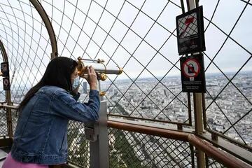 Un visitante disfruta de la vista desde el segundo piso de la Torre Eiffel en París