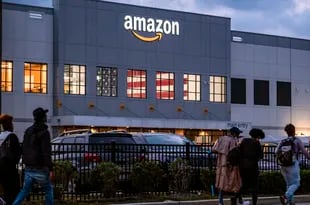 Personas llegan a trabajar al centro de distribución de Amazon en Staten Island, Nueva York, el 25 de octubre de 2021. (AP Foto/Craig Ruttle, File)