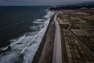 Un nuevo malecón se eleva a lo largo del Pacífico, cerca de la planta de energía nuclear dañada de Fukushima Daiichi en la distancia: una barrera por temor a un nuevo tsunami