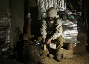 Un militar de las Fuerzas Militares de Ucrania calienta un té en un banquillo en la línea del frente con los separatistas respaldados por Rusia cerca de Gorlivka, región de Donetsk, el 23 de enero de 2022.