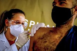El trabajador de salud y voluntario Paulo Roberto Oliveira recibe una vacuna contra el coronavirus producida por la empresa china Sinovac Biotech en el Hospital Sao Lucas, en Porto Alegre, sur de Brasil el 08 de agosto de 2020