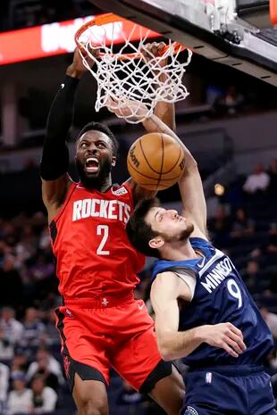 Houston Rockets forward David Nwaba (2) dunks next to Minnesota Timberwolves guard Leandro Bolmaro (9) during the second half of an NBA basketball game Wednesday, Oct. 20, 2021, in Minneapolis. (AP Photo/Andy Clayton-King)
