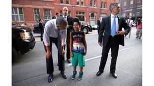 Agentes del Servicio Secreto de Estados Unidos acompañan al Presidente Barack Obama mientras saluda a un joven en la calle en Denver, Colorado, el 8 de julio de 2014.