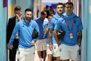 Messi, smiling, arrives at the stadium accompanied by Leandro Paredes and Paulo Dybala