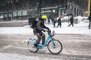 Una persona anda en bicicleta durante la nevada, ayer en Chicago,.