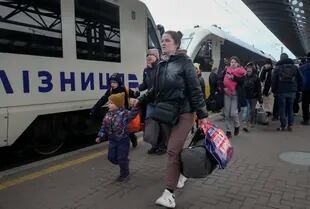 Los padres acompañan a los niños y adolescentes mientras suben a un tren después de salir del Hospital Central de Niños de Kiev, tras su evacuación, en Kiev, Ucrania, el lunes 7 de marzo de 2022. 