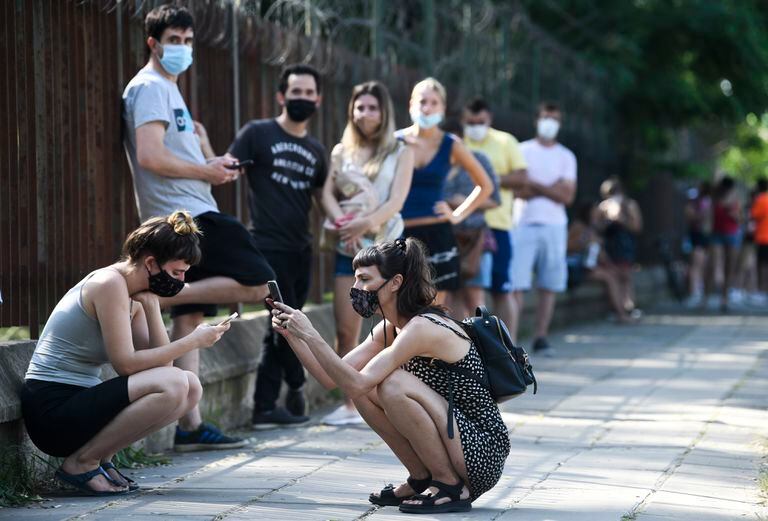 Personas esperan distanciadas socialmente fuera del Parque Centenario para hacerse la prueba gratuita de COVID-19 en Buenos Aires, Argentina, el viernes 31 de diciembre de 2021. (AP Foto/Gustavo Garello)