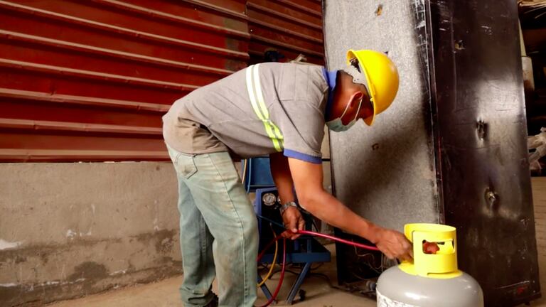 Un trabajador de la empresa de Ángel Toledo extrae gases refrigerantes de un antiguo electrodoméstico