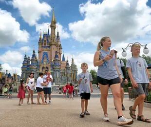 Niños y adultos paseando en Walt Disney World, en Lake Buena Vista, Florida, el 17 de mayo de 2021. (Joe Burbank/Orlando Sentinel via AP)