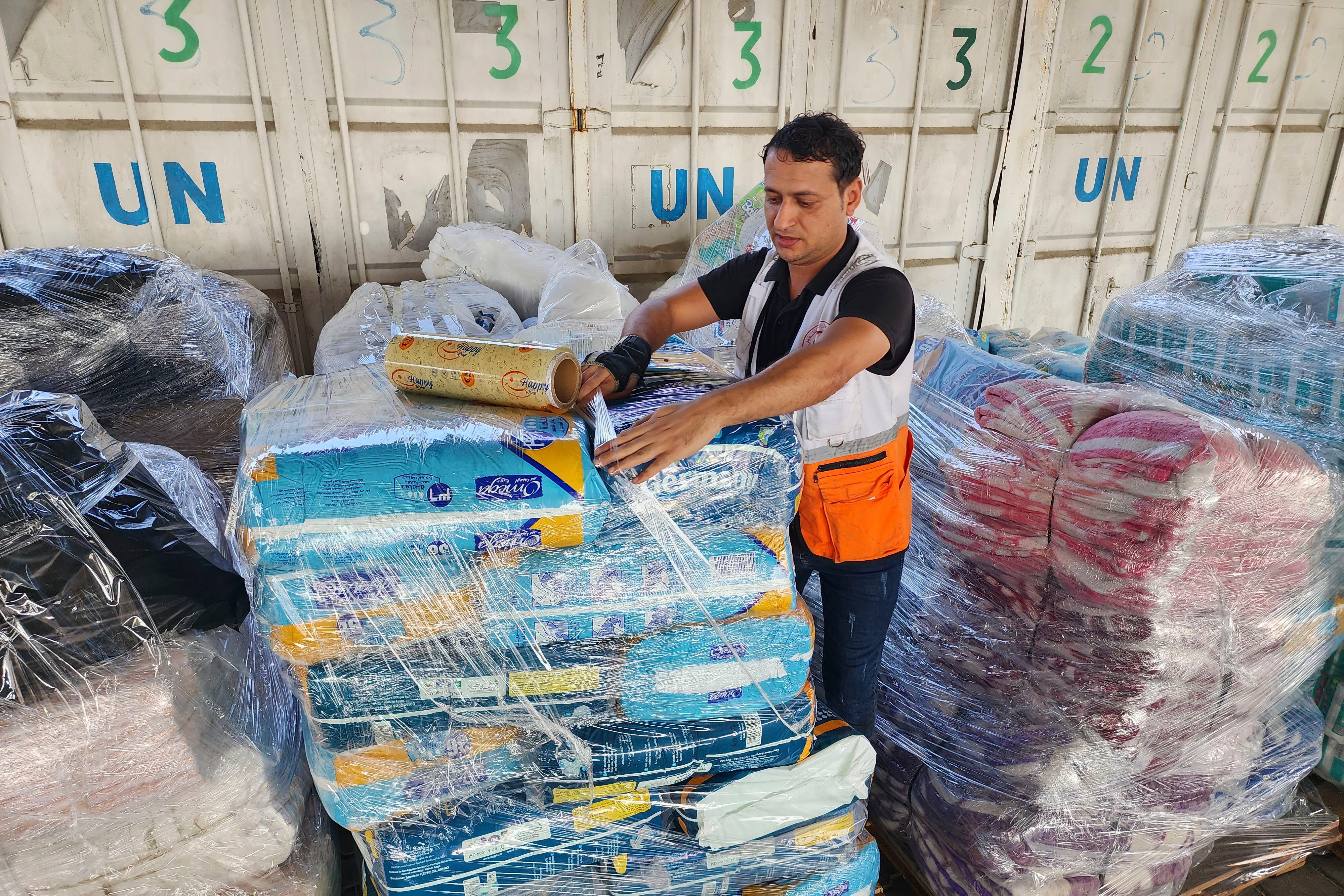 Un trabajador de las Naciones Unidas prepara paquetes de ayuda para su distribución a los palestinos en el almacén de la UNRWA en Deir Al Balah, Franja de Gaza (Archivo)