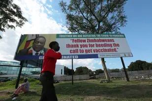 Un chico camina junto a un cartel con la imagen del presidente de Zimbabwe,  Emmerson Mnangagwa. El sur de África está en la mira por el brote de ómicron
