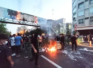 Una imagen obtenida por AFP el 21 de septiembre de 2022, muestra a manifestantes iraníes quemando un cubo de basura en la capital, Teherán, durante una protesta por Mahsa Amini, días después de su muerte bajo custodia policial.