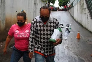 Dos ciudadanos en Manaos transportan un cilindro de oxígeno 
