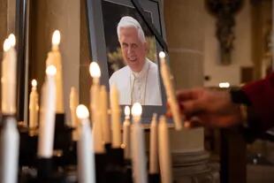 Una persona enciende una vela en la Catedral de Santa María, en Alemania, para el Papa Emérito Benedicto XVI