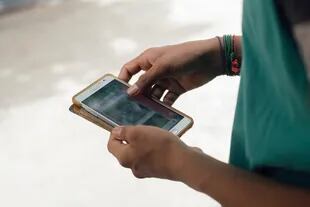 Un joven descarga un video desde la aplicación de WhatsApp