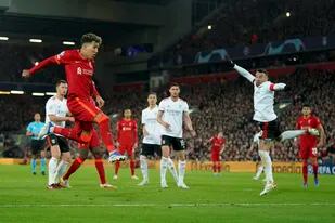 El delantero brasileño Roberto Firmino, segundo de izquierda a derecha, anota el tercer gol del Liverpool en el partido de vuelta de los cuartos de final de la Liga de Campeones ante el Benfica, en el estadio Anfield de Liverpool, Inglaterra, el miércoles 13 de abril de 2022. (AP Foto/Jon Super)