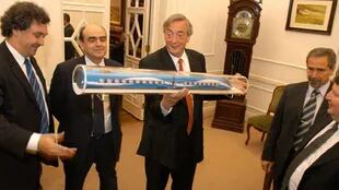 El expresidente Kirchner viendo la maqueta del tren bala; a su izquierda, Ricardo Jaime, entonces ministro de Transporte y el ejecutivo de Alstom, Thibault Desterac