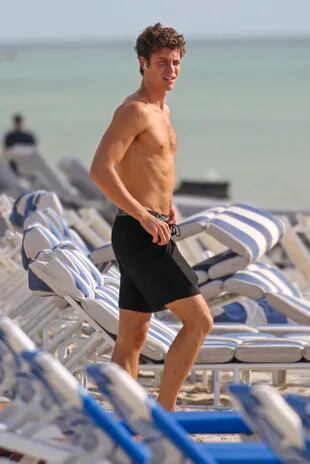 Singer Shawn Mendes takes an early morning trip to the beach and stretches as he's caught in the flashes