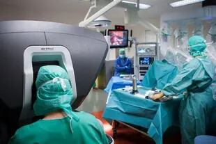 Un cirujano (izquierda) utiliza un robot quirúrgico da Vinci, controlado por una consola, para realizar una histerectomía 