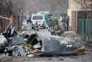 Un soldado ucraniano inspecciona los restos de un avión derribado en Kiev, Ucrania, viernes 25 de febrero de 2022. (AP Foto/Vadim Zamirovsky)
