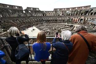 Visitantes toman fotografías a cantantes y músicos de la academia Santa Cecilia que actúan en el emblemático Coliseo de Roma que reabrió en medio de una flexibilización de las restricciones al coronavirus