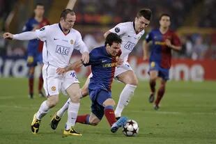 Wayne Rooney, goleador histórico de la selección inglesa, y el defensor Patrick Carrick, encierran a Messi en un partido del United contra Barcelona 