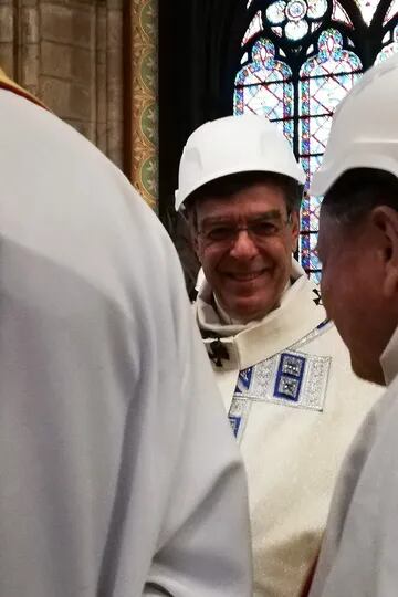 El arzobispo de París, Michel Aupetit, habla con un compañero del clero durante la primera misa luego del incendio que destruyó gran parte del techo y estructuras de Notre Dame