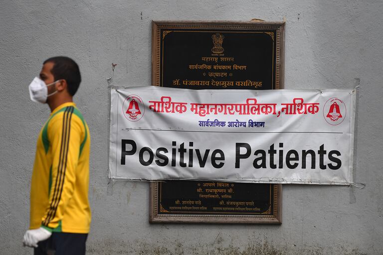 Un hombre pasa junto a un letrero que dice Pacientes positivos durante una prueba de detección de coronavirus en un centro de cuarentena, en Nashik, la India, el 13 de septiembre de 2020