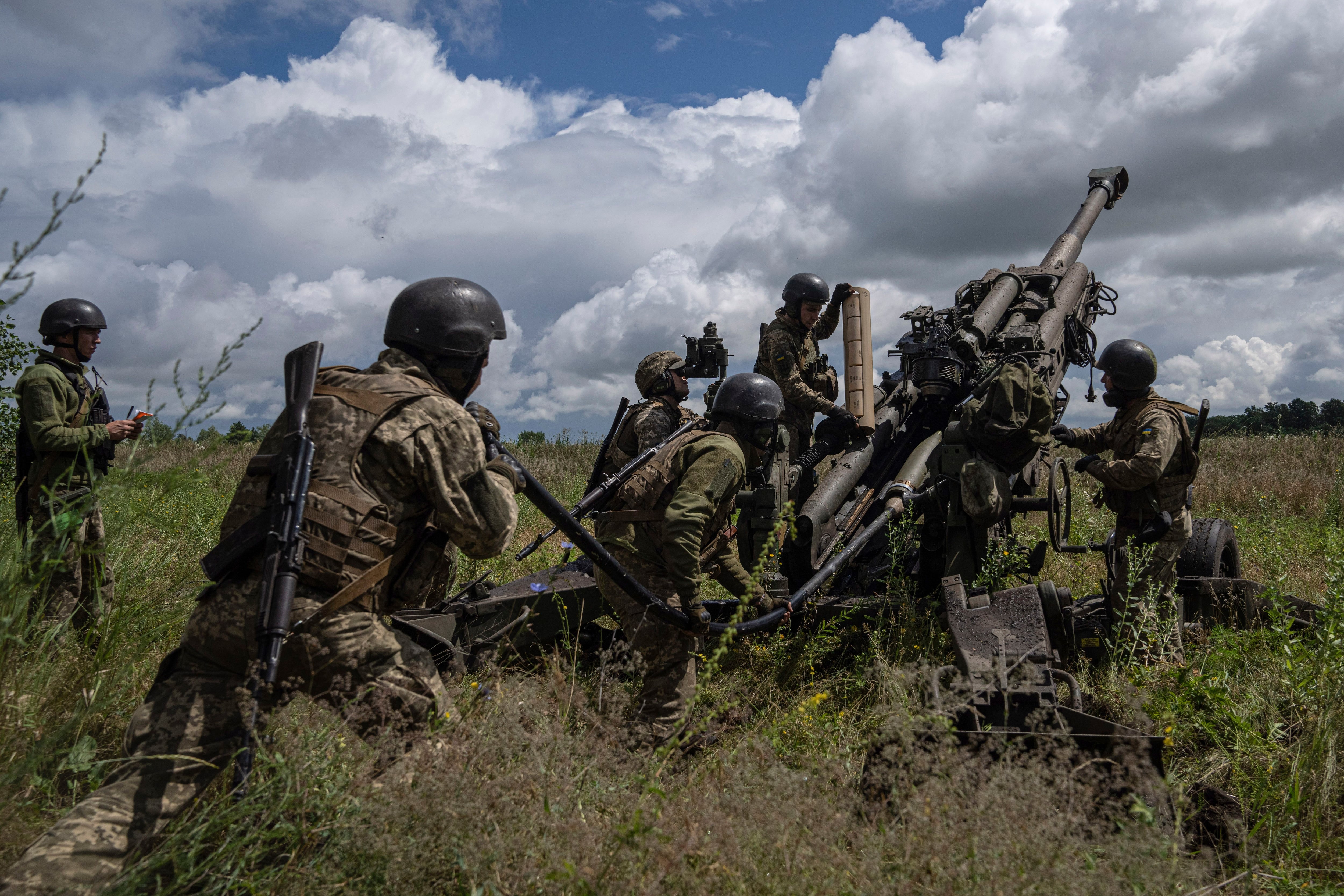 ARCHIVO - Soldados ucranianos se preparan para dispararles a posiciones rusas con un cañón M777 suministrado por Estados Unidos, el 14 de julio de 2022, en la región de Járkiv, Ucrania. (AP Foto/Evgeniy Maloletka, archivo)