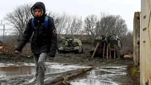 Ucrania: un niño camina con dos tanques a su espalda
