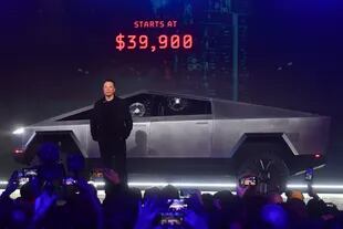 Elon Musk junto a su Tesla Cybertruck; los vidrios laterales se astillaron luego de que les pegó con una pelota 