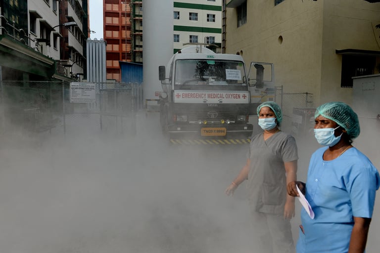 Se puede ver al personal médico en un lugar donde se recarga un camión de transporte de oxígeno líquido en una planta de producción en medio de la pandemia del coronavirus en un hospital en Chennai, la India, el 25 de abril de 2021